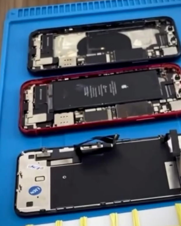 Bancada da assistência técnica da WN iPhones com aparelhos abertos e ferramentas